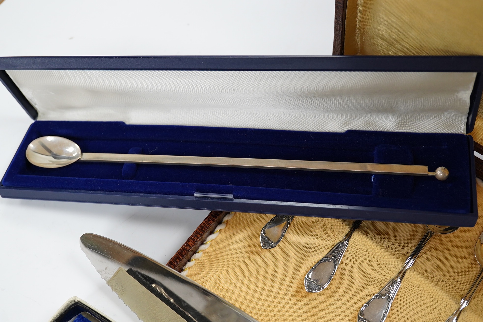 Sundry silver including a silver handled cake slice and similar bread knife, a cased set of six Italian 800 standard coffee spoons, a modern silver mounted desk calendar and an unusual 925 long olive spoon? with removabl
